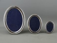 A GRADUATED SET OF THREE OVAL SILVER PORTRAIT FRAMES, 5.5 x 4 cms, 9 x 6 cms and 13.5 x 9.5 cms,