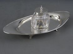A SILVER BOAT SHAPED INK TRAY, 3.2 troy ozs, Sheffield 1916, with centre heavy glass bottle having