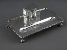 A STYLISH SILVER SINGLE BOTTLE PEN AND INKSTAND, rectangular with beaded border on raised corner