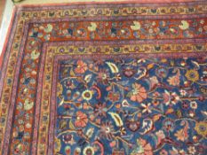 A LARGE EASTERN STYLE RED GROUND CARPET, multi-patterned with narrow tassel ends, 3.4 x 2.6 metres