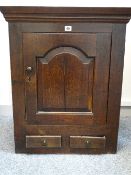 A CIRCA 1800 WALL CUPBOARD with single chamfered panelled door above twin lower drawers, peg