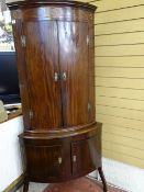 AN ANTIQUE REPRODUCTION TWO PIECE CORNER CUPBOARD, the upper section having two bow fronted doors