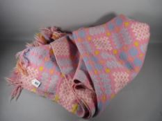 A WELSH WOOLLEN BLANKET, pink, blue and yellow ground with repeating block pattern (repaired patch),