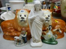 Pair of Staffs pottery recumbent lions with glass eyes, a composite figure of Christ and two pottery