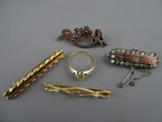 Four Victorian bar brooches in fifteen carat gold and other metals, one having garnet type
