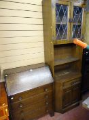 Oak three drawer writing bureau and an oak bookcase cupboard with twin upper leaded glazed doors