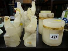 Four pairs of carved alabaster bird bookends, two lidded pots and an onyx example