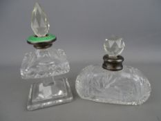 Two cut glass scent bottles with facet cut stoppers and silver collars