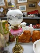 Victorian brass column oil lamp with painted pink glass font, cone wick adjusters and a later etched