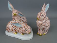 Herend Hungary hand painted porcelain figurines showing a single seated rabbit and a pair