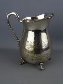 Bulbous four footed vintage EPNS water jug with chased floral decoration