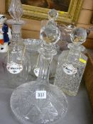 Cut glass ship's type decanter and three further glass decanters with ceramic drinks labels