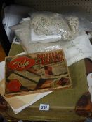 Vintage leather bound suitcase, quantity of table linen, boxed Russian cake tin etc