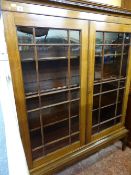 Dentil cornice topped twin glazed door display cabinet on raised tapered supports