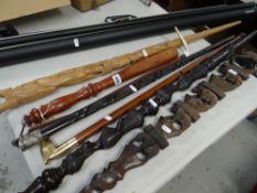 Two African carved tribal pointed staffs, an Argentina souvenir carved staff, a horn handled