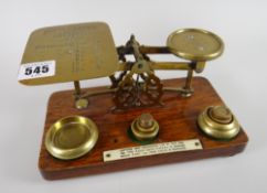 A lovely vintage set of postal scales on a wooden stand with weights and mounted instructions for