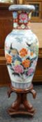 A twentieth century floor standing Oriental baluster vase on a decorative wooden stand, 135cms