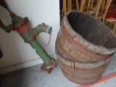 An antique cast iron garden water pump together with two iron bound wooden barrel-type planters