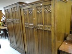A pair of matching carved panelled wardrobes and a matching dressing table with three centre drawers