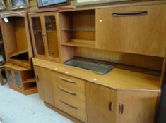 A mid-century G-Plan lounge unit with glazed top and cupboard and drawers to the base together