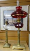 Two oil lamps - one with Corinthian Romanesque column base on a rectangular stand with ruby glass
