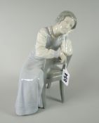 A B&G Copenhagen porcelain figure of a lady in a long night-dress leaning on her hand, 23cms high