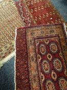 Three Persian red ground rugs with geometric borders, 145 x 83cms, 121 x 100cms & 124 x 75cms