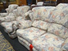 Modern fabric upholstered floral decorated three-piece suite comprising two-seater settee and two