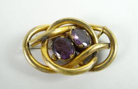 A believed gold knot brooch set with two faceted oval amethysts Condition reports provided on