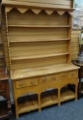 A pine dresser with platform base having three drawers and three shelf open rack, 136cms wide