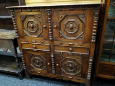 Jacobean-style oak cupboard chest having two cupboards above two drawers raised on stile-type
