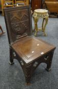 Oak shield back hall chair having Gothic designs, the shield depicting lions, axes and arrows, 89cms