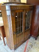 A good standing linen-fold and glazed bookcase with railback, 92cms wide (one pane of glass damaged)