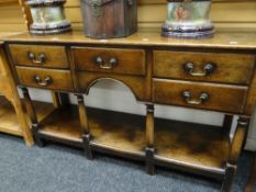 A good nineteenth century-style reproduction oak dresser-base having a single plank platform base