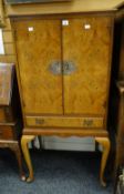 A vintage polished burr wood standing two-door cocktail cabinet with base drawer on cabriole