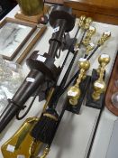 A pair of antique brass fire dogs, a brass handled fire companion set and a pair of metallic wall