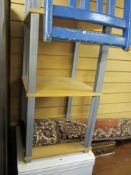 White chest of five drawers, modern light wood four tier shelf unit and two painted chairs along