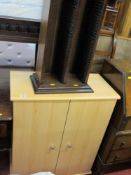 Modern light wood two door cupboard with interior shelving along with a CD storage rack