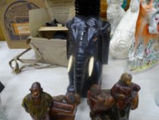 Pair of glazed terracotta Continental figures and a carved elephant brush holder