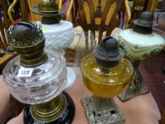 Four oil lamps including milk glass, amber glass etc