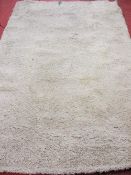 Ivory coloured shaggy style rug, 290 x 200 cms