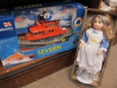 Boxed radio controlled RNLI Lifeboat and a porcelain 'Alice in Wonderland' doll on a stand