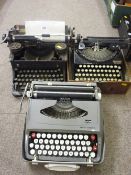 Three vintage portable typewriters by Woodstock, Remington and Smith Corona