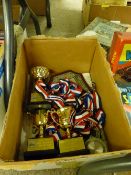 Box of modern medals and sporting trophies, mainly women's triathlon