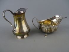 Silver cream jug and a three footed sauce boat, 10 cms high, Birmingham 1965, 14.5 cms long,