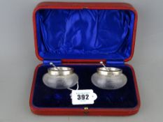 Cased pair of ribbed glass salts with hallmarked silver collars and spoons