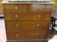 Dark mahogany chest of three long and two short drawers with brass ring handles