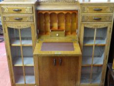 Carved two door glazed display cabinet with two upper drawers and central bureau section over