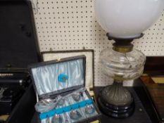 White metal columned vintage oil lamp and a quantity of cased cutlery