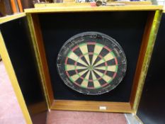 Winmau dartboard in a scoring cabinet with a quantity of darts